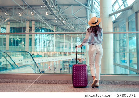 Young woman in hat with baggage in international airport. 57809371