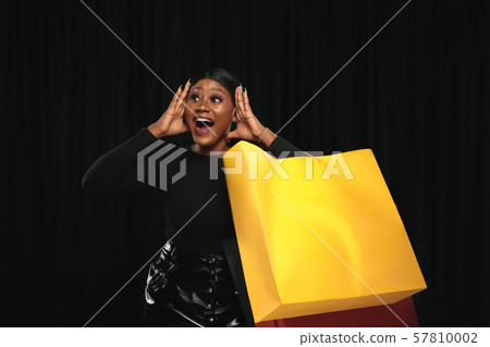 Young woman in dress shopping on black background Young woman in dress shopping on black background 57810002
