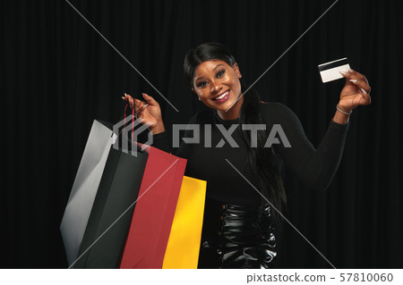 Young woman in dress shopping on black background 57810060