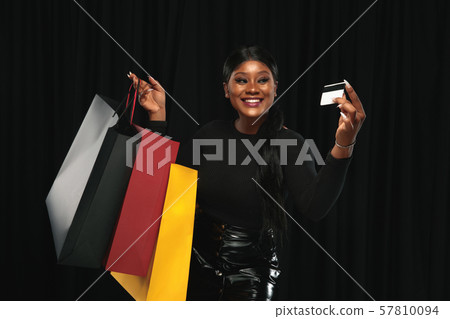 Young woman in dress shopping on black background 57810094
