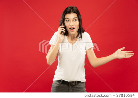 Caucasian young woman's half-length portrait on red background 57810584