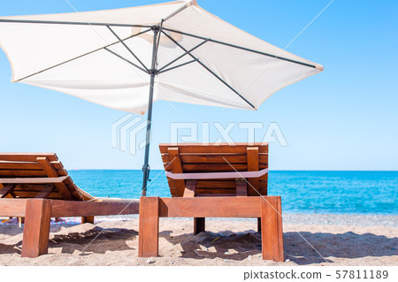 White lounge chairs on a beautiful tropical beach at Maldives White lounge chairs on a beautiful tropical beach at Maldives 57811189
