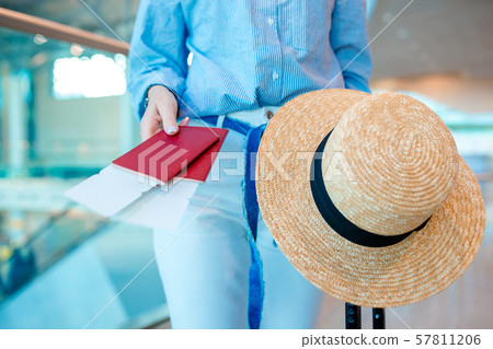 Closeup of woman holding passports and boarding pass at airport Closeup of woman holding passports and boarding pass at airport 57811206