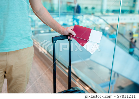 Closeup of man holding passports and boarding pass at airport Closeup of man holding passports and boarding pass at airport 57811211