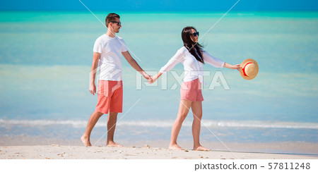 Young couple on white beach. Happy family on honeymoon vacation Young couple on white beach. Happy family on honeymoon vacation 57811248