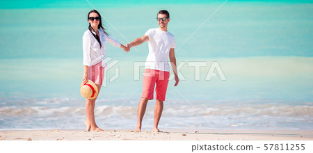 Young couple on white beach. Happy family on honeymoon vacation Young couple on white beach. Happy family on honeymoon vacation 57811255