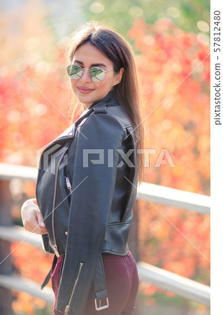 Fall concept - beautiful woman drinking coffee in autumn park under fall foliage Fall concept - beautiful woman drinking coffee in autumn park under fall foliage 57812480