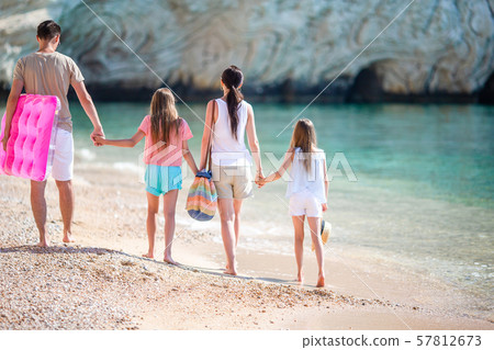 Happy beautiful family on white beach having fun together Happy beautiful family on white beach having fun together 57812673