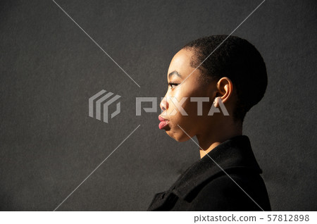 portrait of young cool stylish skin head African woman in natural light ob grey background 57812898