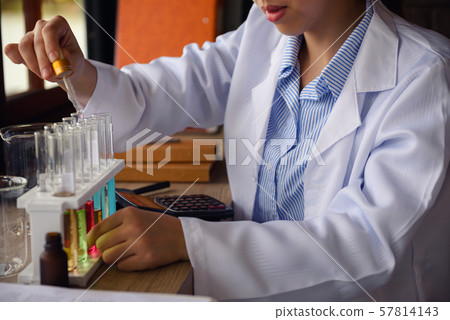 scientist hand drop chemical liquid to tube 57814143