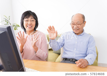 Elderly couple making telephone calls on personal computers Elderly couple making telephone calls on personal computers 57814608