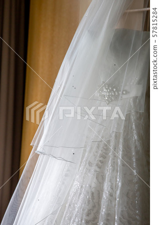 Bridal dress hanging at wooden closet Bridal dress hanging at wooden closet 57815284