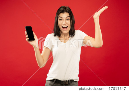 Caucasian young woman's half-length portrait on red background 57815847