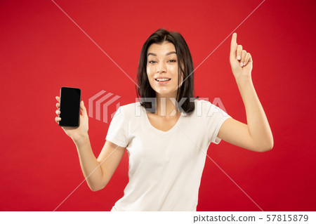 Caucasian young woman's half-length portrait on red background Caucasian young woman's half-length portrait on red background 57815879