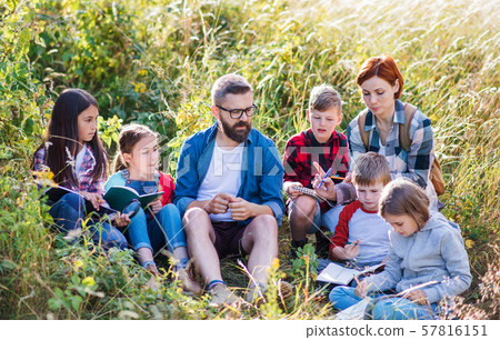Group of school children with teacher on field trip in nature. 57816151