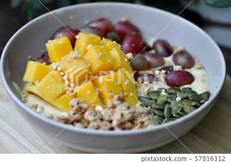 smoothie bowl, mango yogurt with fruit topping 57816312