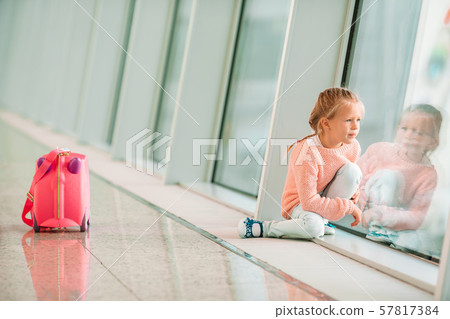 Adorable little girl in airport with her luggage waiting for boarding 57817384