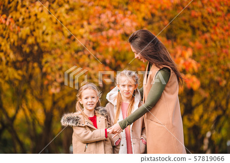 Little girl with mom outdoors in park at autumn day 57819066