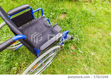 Empty wheelchair standing on grass in hospital 57821046