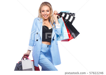 Beautiful girl with Hollywood locks, classic make-up in a elegant blue suit and shopping bags Beautiful girl with Hollywood locks, classic make-up in a elegant blue suit and shopping bags 57822246
