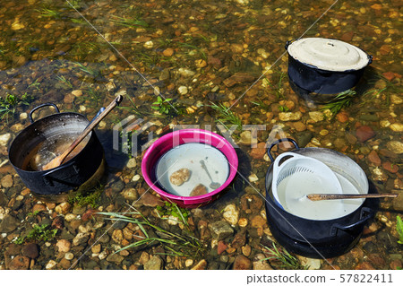 Tourists soaked kitchen utensils in the river. 57822411