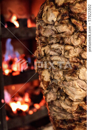 Close up shot of stacked meat roasting to be used in preparation of traditional Greek dish gyros or 57822802