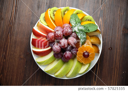Sliced fruits on a white plate . catering menu 57825335