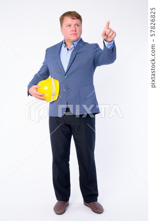 Full body shot of overweight businessman as engineer pointing finger and directing 57826825