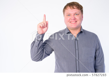 Portrait of happy overweight businessman pointing finger up 57827283