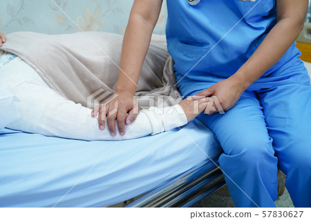 Asian nurse physiotherapist doctor care, help and support senior or elderly old lady woman patient lie down in bed at hospital ward Asian nurse physiotherapist doctor care, help and support senior or elderly old lady woman patient lie down in bed at hospital ward 57830627