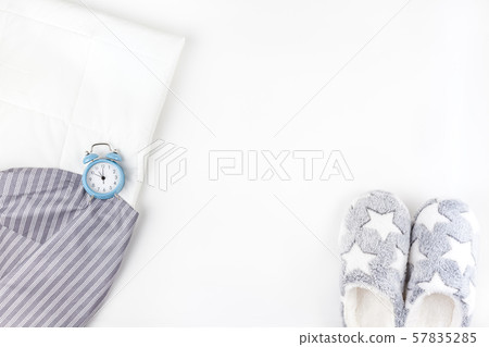 Soft fluffy slippers and blue alarm clock 57835285