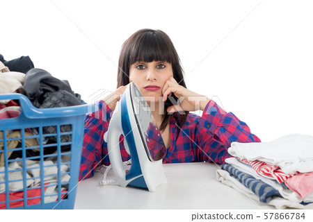 unhappy young beautiful woman ironing clothes 57866784