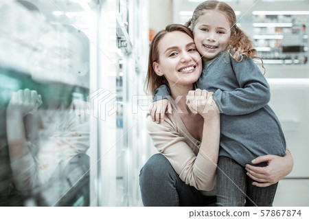 Mom laughing and hugging with kid in the apothecary shop. 57867874