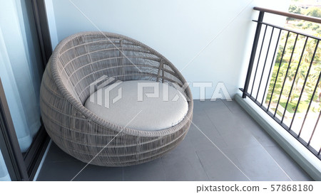 Outdoor beach chair on the hotel room balcony or terrace which made from natural wood called rattan and brown color round shape and look luxury for relaxing or sleeping or for party. Outdoor beach chair on the hotel room balcony or terrace which made from natural wood called rattan and brown color round shape and look luxury for relaxing or sleeping or for party. 57868180