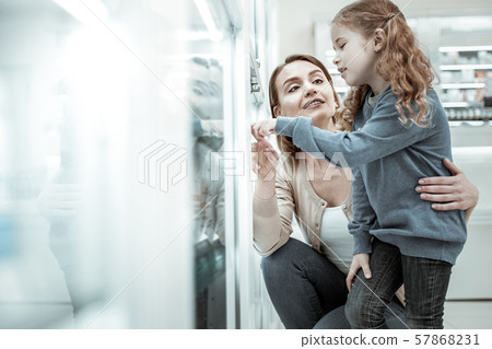 A loving mother assisting her daughter with a vitamins choice. A loving mother assisting her daughter with a vitamins choice. 57868231