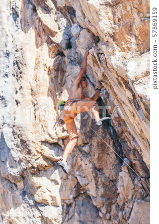 Man climbing a rock. 57869159
