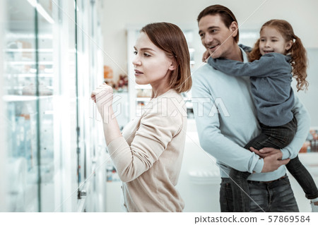 Loving mother choosing vitamins with her family in the drugstore Loving mother choosing vitamins with her family in the drugstore 57869584
