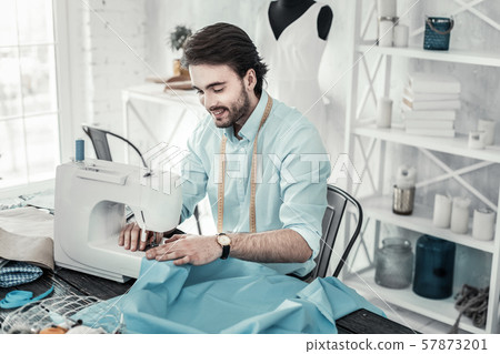 Pleased young bearded man working in design studio 57873201