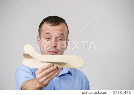Fly fear. Man holding airplane in hand 57881476