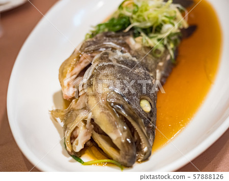 Fish in soy sauce, served on white plate 57888126