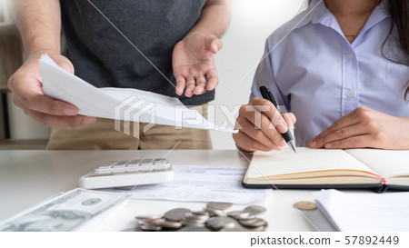 couple working saving account book and calculating couple working saving account book and calculating 57892449