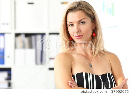 Blonde attractive woman standing at office workplace looking in camera Blonde attractive woman standing at office workplace looking in camera 57902075
