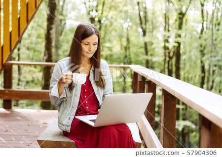 woman with laptop and coffee outside woman with laptop and coffee outside 57904306