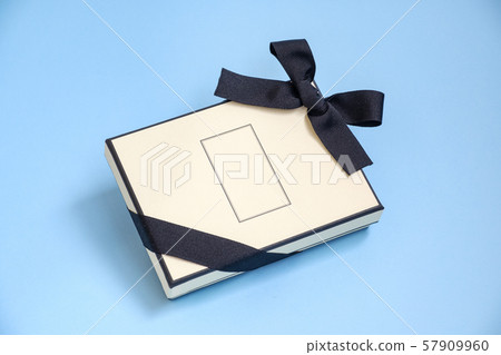 Gift box with colored ribbon as a gift isolated on a blue background, top view. Gift box with colored ribbon as a gift isolated on a blue background, top view. 57909960