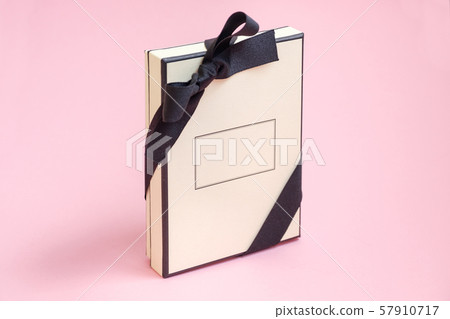 Gift box with colored ribbon as a gift isolated on a pink background, top view.  57910717