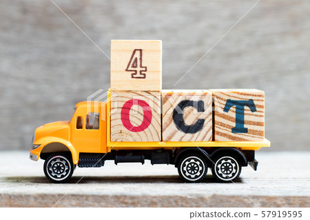 Truck hold letter block in word 4oct on wood background Truck hold letter block in word 4oct on wood background 57919595