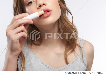 Charming teen girl with beautiful full lips using hygienic lipstick 57922062