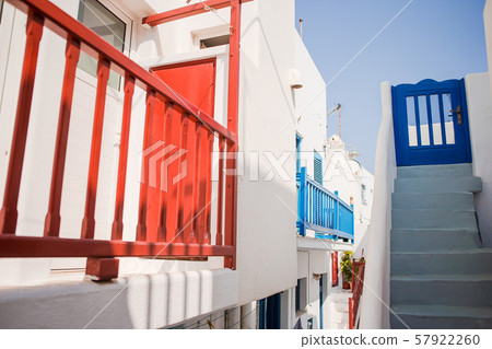 The narrow streets of the island with blue balconies, stairs and flowers. 57922260