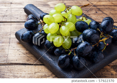 Clusters of black and green grapes Kish Mish on a wooden Board. Copy space. 57922370