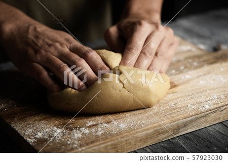 young man kneading a piece of dough 57923030